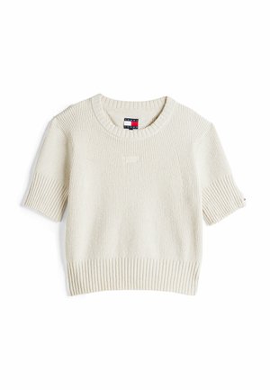 Crème trui met korte mouwen, geribbelde textuur, ronde hals en subtiele Tommy Jeans-logo. Heeft een rechte zoom en brede mouwen.