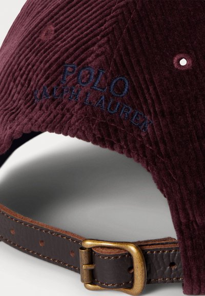 Mørk burgunder corduroy baseball caps med marineblå "POLO RALPH LAUREN" broderi. Brun lærjusterbar stropp med detaljer i gullspenne.