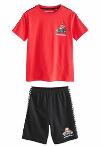 Camiseta de algodón roja con un gráfico de Mario y el texto "MARIOKART". Pantalones cortos negros con franjas laterales a cuadros y un logo de champiñón, con un cinturón elástico.
