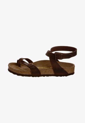 Brown leather sandal featuring crisscross straps, an ankle strap with a buckle, and a cork footbed with a textured surface.