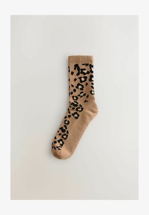 Rudos kojinės su ribotu kraštu, puoštos juodu leopardinio rašto motyvu. Minkšta tekstūra, ilgis iki vidurio blauzdos, susiūtos be siūlių pirštų srityje.