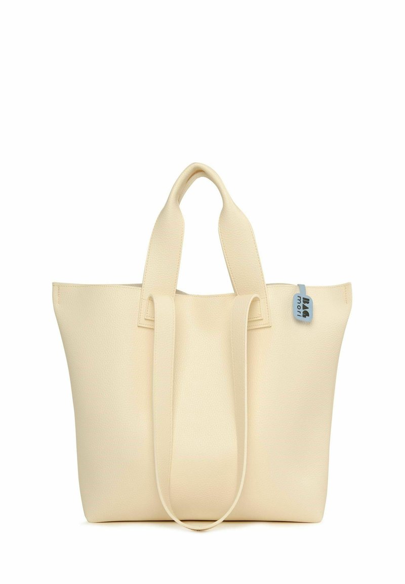 Sac fourre-tout couleur crème en cuir texturé, avec deux poignées plates et une petite étiquette bleue portant une marque. Design simple et structuré.