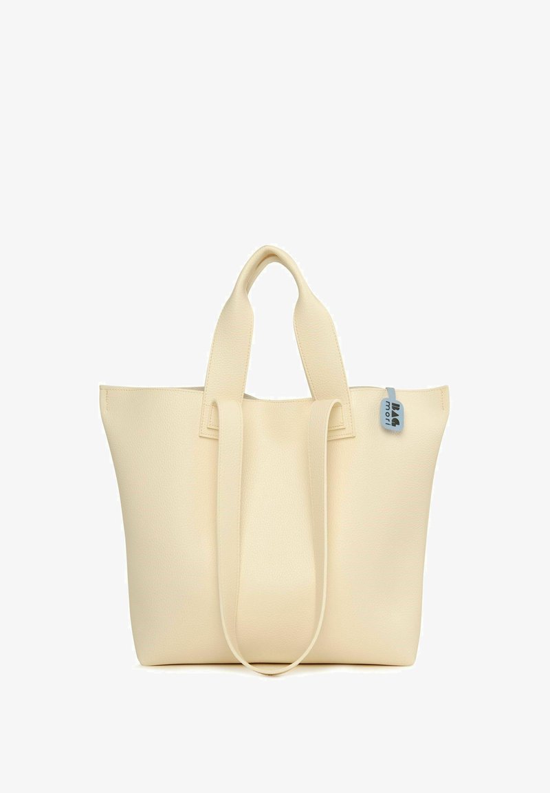 Sac fourre-tout couleur crème en cuir texturé, avec deux poignées plates et une petite étiquette bleue portant une marque. Design simple et structuré.
