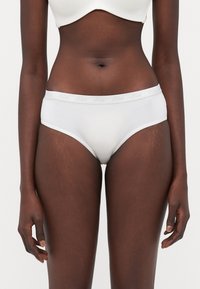 White cotton hipster underwear with a soft elastic waistband featuring a subtle logo. Smooth texture, classic cut, minimal design.