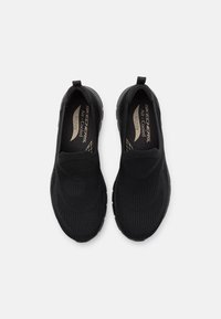 Black slip-on shoes with a textured upper and cushioned insole. Features a flexible sole and reinforced heel for comfort and support.