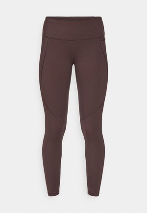 Leggings marroni a vita alta con una texture liscia, caratterizzati da dettagli di cucitura sottili e un design aderente per comfort e flessibilità.