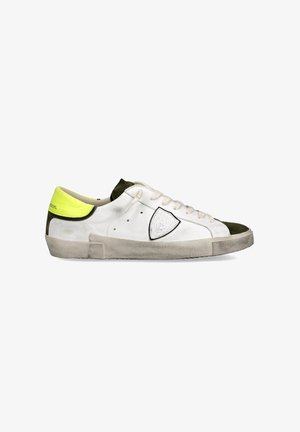 Baskets blanches et vertes avec un capuchon en daim, un corps en cuir texturé blanc et un accent de talon jaune fluo. Présente des lacets plats et un détail de logo.