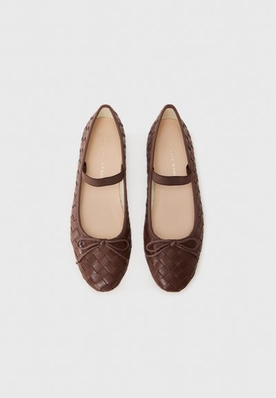 Ballerines tressées marron avec un bout rond, dotées d'un petit nœud à l'avant et d'une doublure intérieure beige lisse.