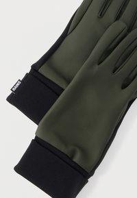 Πράσινα και μαύρα γάντια κατασκευασμένα από λείο, αδιάβροχο υλικό με ριμπ μαύρη μανσέτα. Διαθέτουν λεπτομέρειες στα δάχτυλα για ευχέρεια κινήσεων.