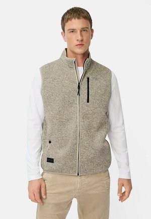 Gray fleece vest with high collar, front zipper, and black zippered pocket. Worn over a white long-sleeve shirt and beige pants.
