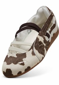 Bailarinas con un estampado de vaca en pelo sintético marrón y crema. Presentan correas elásticas y una suela de goma marrón.