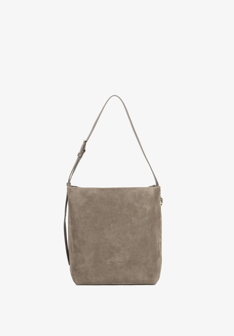 Sac à bandoulière en daim gris de forme carrée avec une longue sangle réglable et des coutures visibles minimales sur un fond uni.
