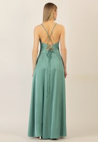 Maxikleid aus satinfarbenem Stoff in Petrol mit tailliertem Oberteil, gekreuzten Rückenträgern und einem fließenden Rock, der bis zum Boden reicht.