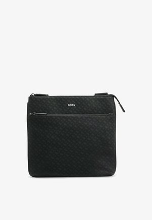 Sac synthétique noir avec une finition mate et un motif en relief. Comprend une fermeture zippée sur le dessus et une poche zippée à l'avant. Logo de la marque affiché de manière proéminente.