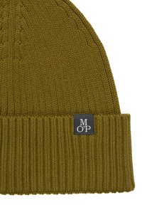 Oliwkowa dzianinowa czapka z prążkowanym mankietem i kwadratową czarną metką z białym napisem "M O' P" po boku.