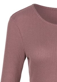 Geripptes langärmeliges Oberteil in gedämpftem Mauve. Verfügt über einen runden Ausschnitt und texturierten Stoff, der eine enganliegende Passform betont.