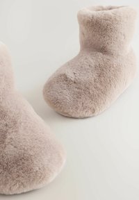 Udu, hele roosad sussiketsid ümmarguse kujuga ning äärega. Pehme tekstuur kerge läikega; nähtavat riistvara ega mustreid pole.