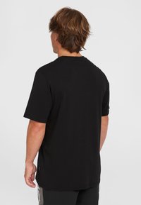 Sort bomulds t-shirt med korte ærmer, rund hals og en afslappet pasform. Bagsiden har en glat tekstur uden synlige logoer eller mønstre.