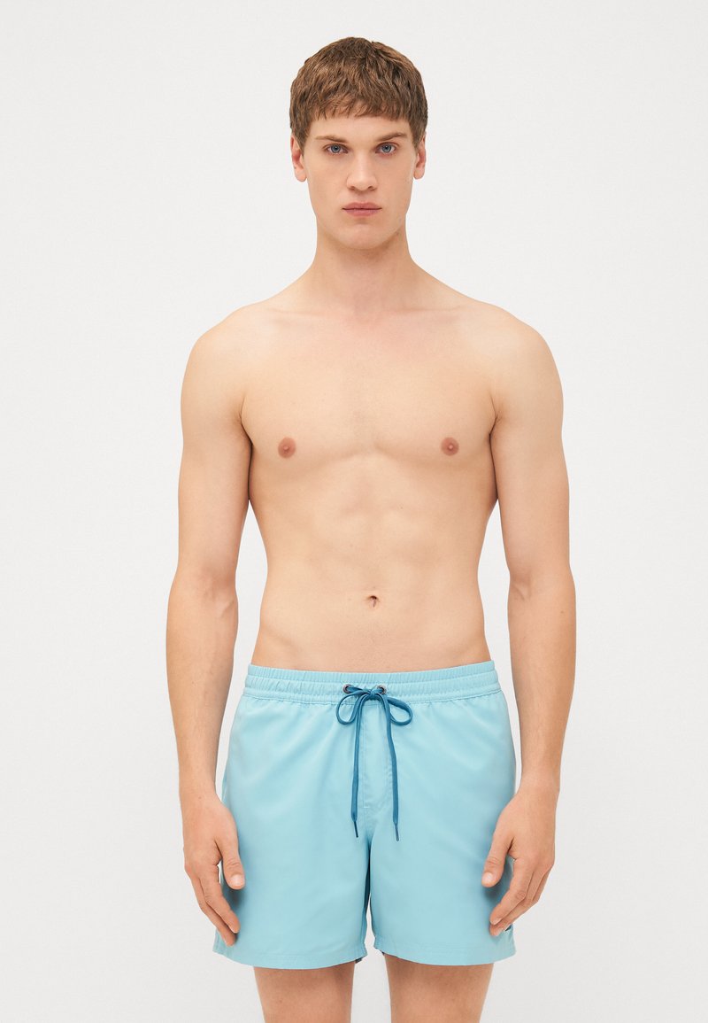 Pantaloni scurți de baie bleu deschis, cu un brâu elastic, șnur albastru și un material neted, care se usucă rapid. Fără modele sau accente vizibile.
