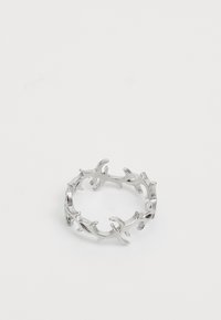 Bague en métal argenté avec un design ajouré ressemblant à des branches abstraites connectées ou à des formes de corail, présentée sur un fond blanc uni.