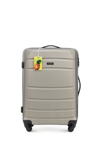 Zilveren harde koffer met een gestructureerd oppervlak, zwarte wielen en handvat. Inclusief een kleurrijke tag in de vorm van een ananas.