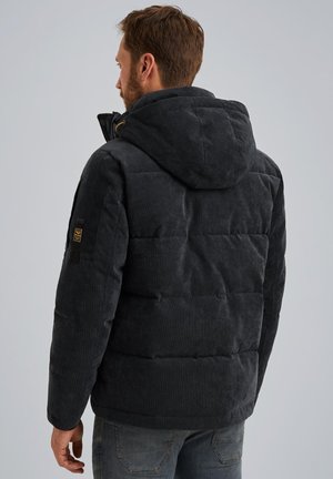 Black corduroy puffer jacket with a hood, featuring quilted sections, side pockets, and a logo patch on the left sleeve.