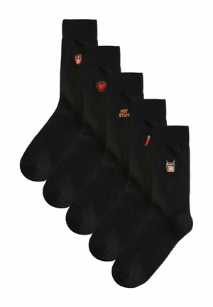 Vijf zwarte sokken, elk met kleine kleurrijke borduurwerk: brandend hart, rood hart, tekst "HOT STUFF", chilipeper en pittig drankje.