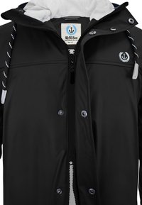 Black waterproof jacket with a zip closure, white fleece lining, adjustable hood with drawstrings, and logo on the chest.