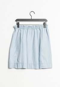 Vaaleansininen farkkuhame, jossa on joustava vyötärö, kerrostunut rakenne ja suora siluetti. Roikkuu mustassa muovihengästä.