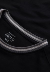 Schwarzes Rundhals-T-Shirt mit grau-weißer Streifenborte, auf dem innen am Kragen das Markenlabel "EXIMIO" und die Größe M (48) zu sehen sind.