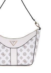 Sac à main blanc avec un sommet incurvé, surface texturée et motifs en relief. Il présente un logo en triangle doré et des finitions noires.