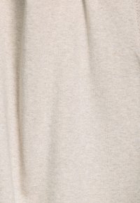 Beige katoenstof met een zachte textuur, met een lichte glans en een subtiele, uniforme weving. Geen patronen of opvallende accenten aanwezig.
