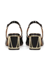 Μαύρα παπούτσια με λουστρίνι, με γεωμετρική χρυσή λεπτομέρεια στη χοντρή σόλα και ρυθμιζόμενο λουράκι στον αστράγαλο. Λείο υλικό, κομψός σχεδιασμός.