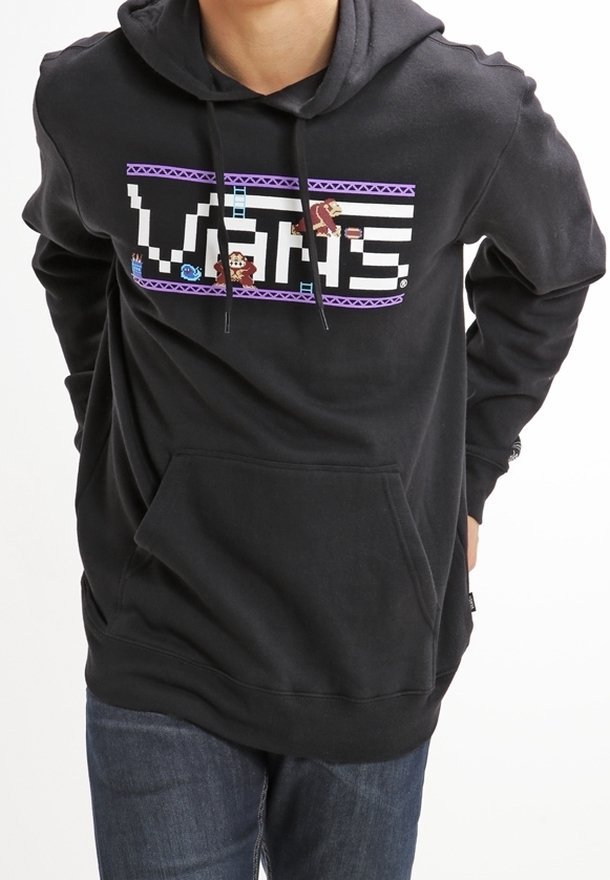 Sweat à capuche noir avec un design graphique comprenant le texte "VANS" et des éléments de jeu vidéo. Comprend une poche frontale et une capuche avec cordon de serrage ajustable.