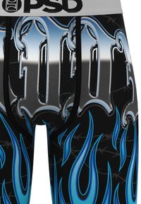 Primo piano di pantaloncini neri con fiamme blu, scritte grigie in stile Old English e una fascia in vita bianca con logo "PSD" nero.