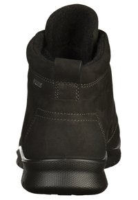 Stivaletti neri in suede con una morbida fodera interna, punta arrotondata e suola in gomma texture. Presentano un pratico linguetta e dettagli di cucitura sottili.