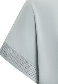 Light blue garment featuring a smooth fabric with a decorative silver rhinestone trim along the hem. The design includes an angled sleeve.