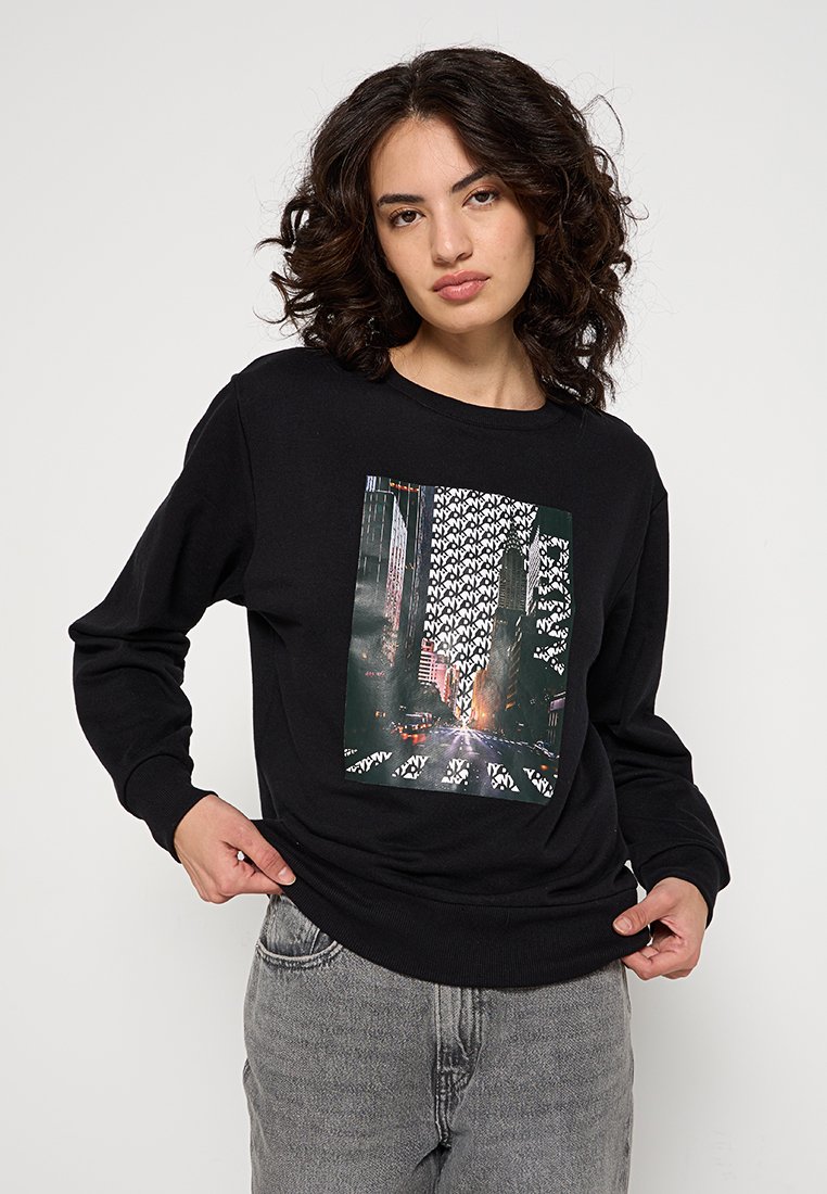 Sudadera negra de manga larga, con un gráfico central de una escena de calle de la ciudad y patrones geométricos blancos sobre gris.