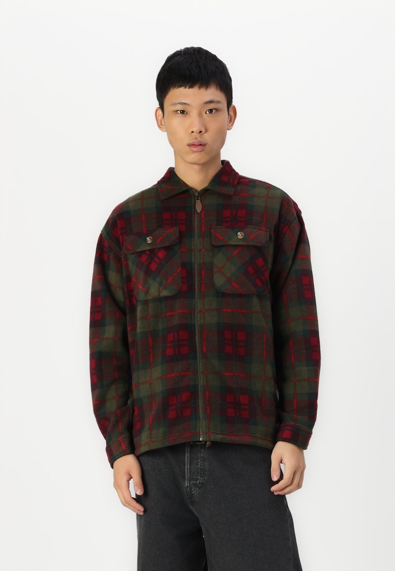 Rot und grün karierter Flanelljacke mit einem Frontreißverschluss, zwei Brusttaschen und einem Kragen. Weicher Stoff und entspannte Passform.