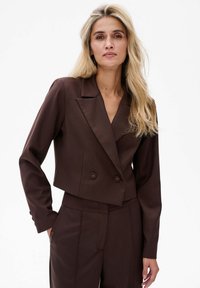 Brązowa krótka marynarka z klapami, podwójnym zapięciem na guziki i długimi rękawami. Gładki materiał z dopasowanym krojem.