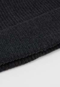 Black knitted scarf with a textured ribbed pattern and a clean edge, showcasing a soft, warm wool blend fabric.