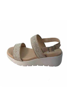 Sandalo a zeppa con fasce superiori intrecciate beige, soletta in pelle liscia e suola in gomma bianca. Presenta una fibbia regolabile sulla cinghia alla caviglia.