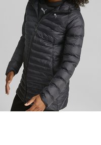 Chaqueta de plumas negra con textura acolchada, cierre frontal con cremallera y capucha. Presenta un logo en el pecho y puños elásticos para mayor calidez.