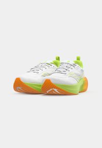 Baskets de sport blanches avec une tige en maille, accentuées de vert citron, avec une semelle orange et des lacets gris. Design arrondi pour un confort amélioré.