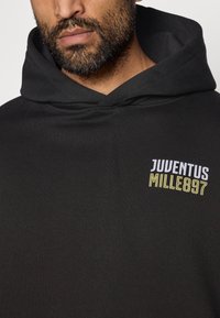 Mustast puuvillasegu kangast kapuutsiga sviiter. Esiküljel on valge ja kollane "JUVENTUS MILLE897" logo.