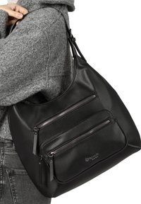 Sac hobo en cuir noir avec surface texturée, deux poches avant zippées et une bandoulière ajustable. Fini lisse, forme arrondie.