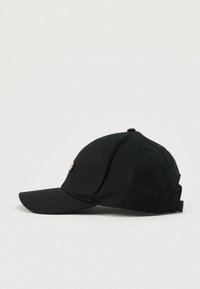 Casquette de baseball noire en coton avec une visière courbée, ornée d'un emblème doré à l'avant et d'une conception de couronne structurée. Sangle arrière réglable.