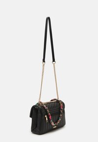 Sac à main noir matelassé avec une anse en chaîne dorée agrémentée de détails tissés colorés, une poche zippée à l'avant et une forme rectangulaire structurée.