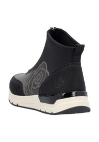 Schwarze Knöchelstiefel mit einem Reißverschluss, ausgestattet mit einem strukturierten grauen Blumenmuster, glatten Lederakzenten und einer weißen Gummisohle mit schwarzem Rand.