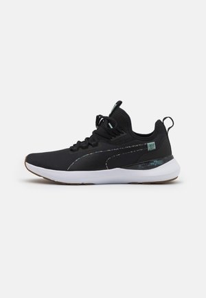 Sneakers basses noires avec semelle blanche, lacets noirs et détail multicolore subtil le long de la bande latérale et du logo sur le talon.